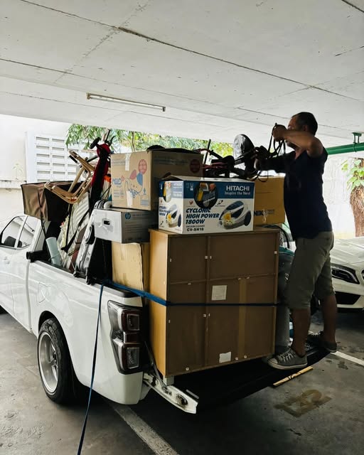 自転車や日用品をまとめて積み込むスタッフ